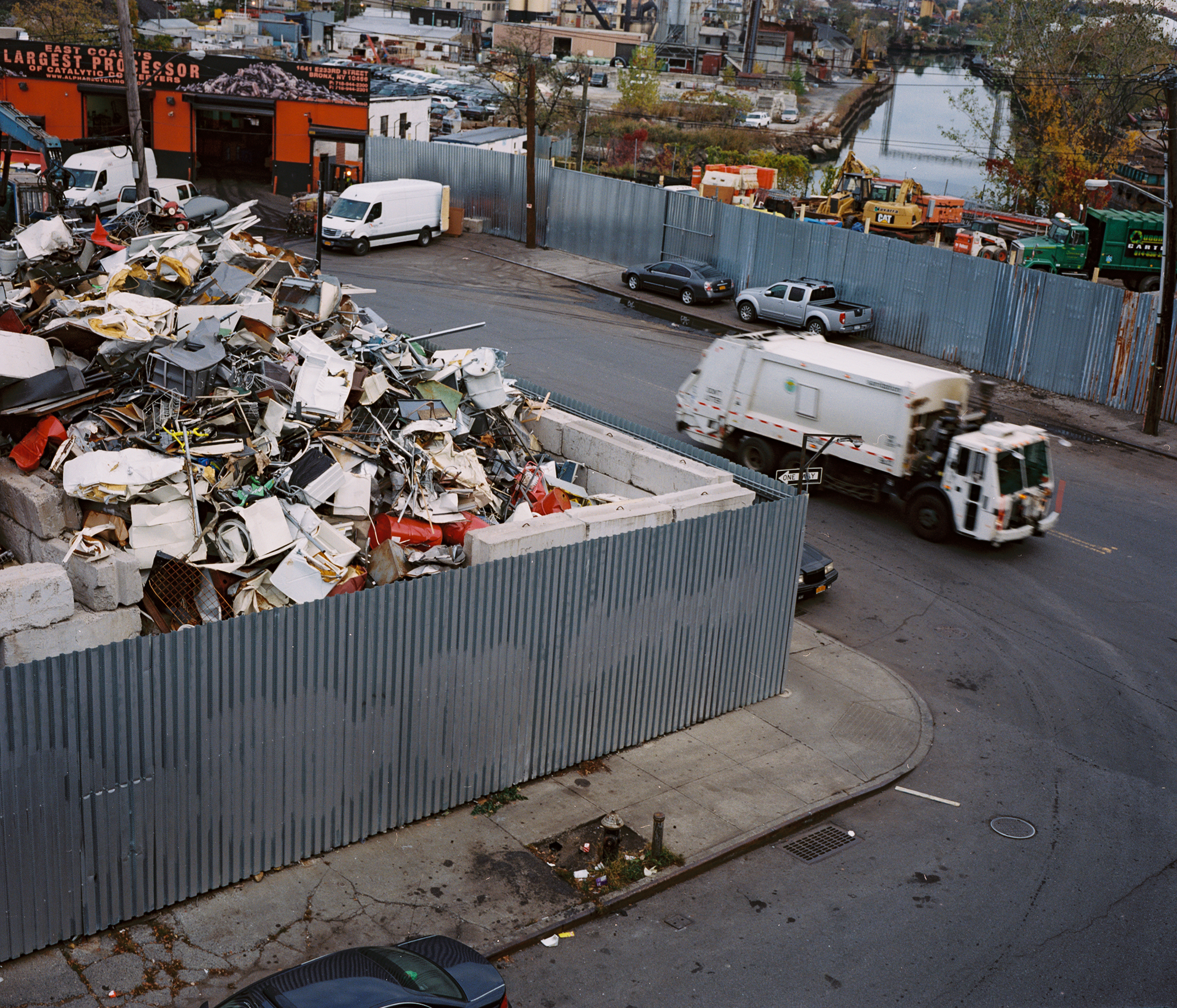 A garbage truck drives by a lot filled with trash.