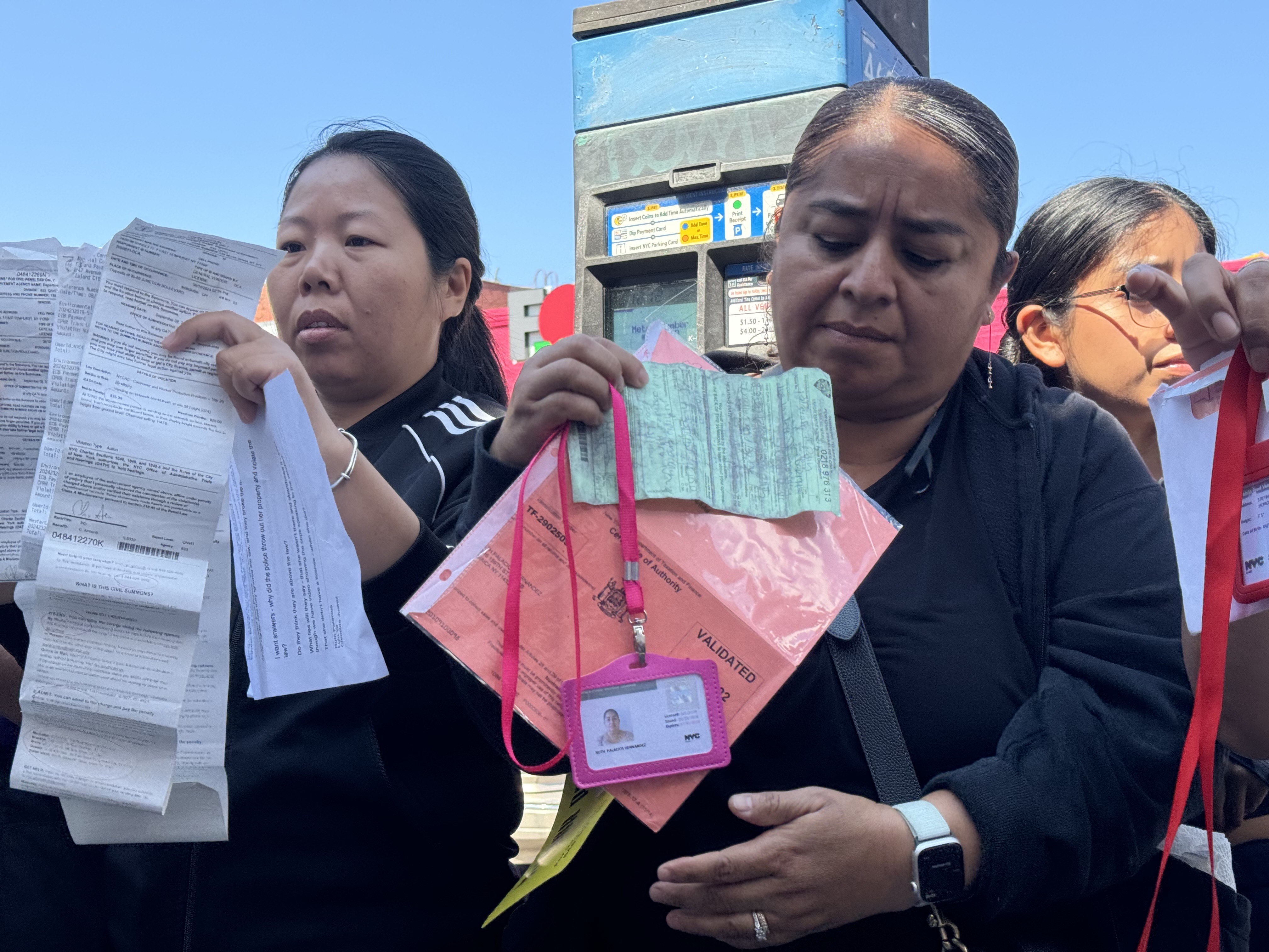 Street vendors in Corona, Queens, display citations they received from the NYPD for vending-related violations, including vending without a permit. The Advocacy group Street Vendors Project contends the vendors are illegally having their carts confiscated and destroyed by the NYPD.