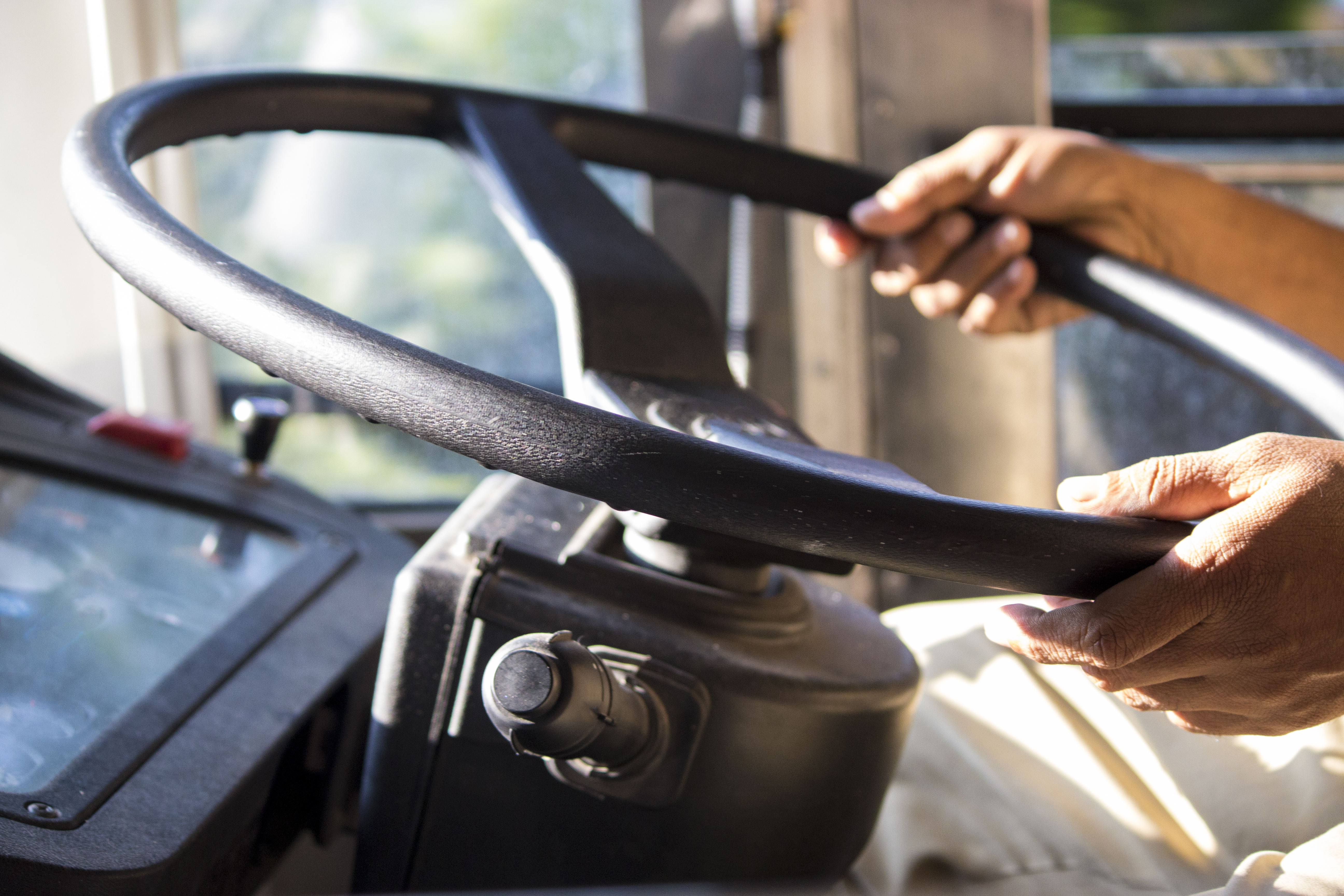 A bus driver's hands on the steering wheel