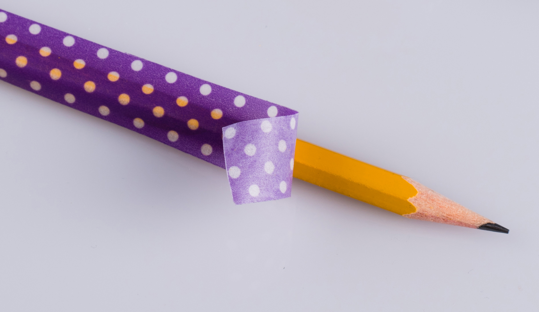 A pencil wrapped in purple polka dot Washi tape.