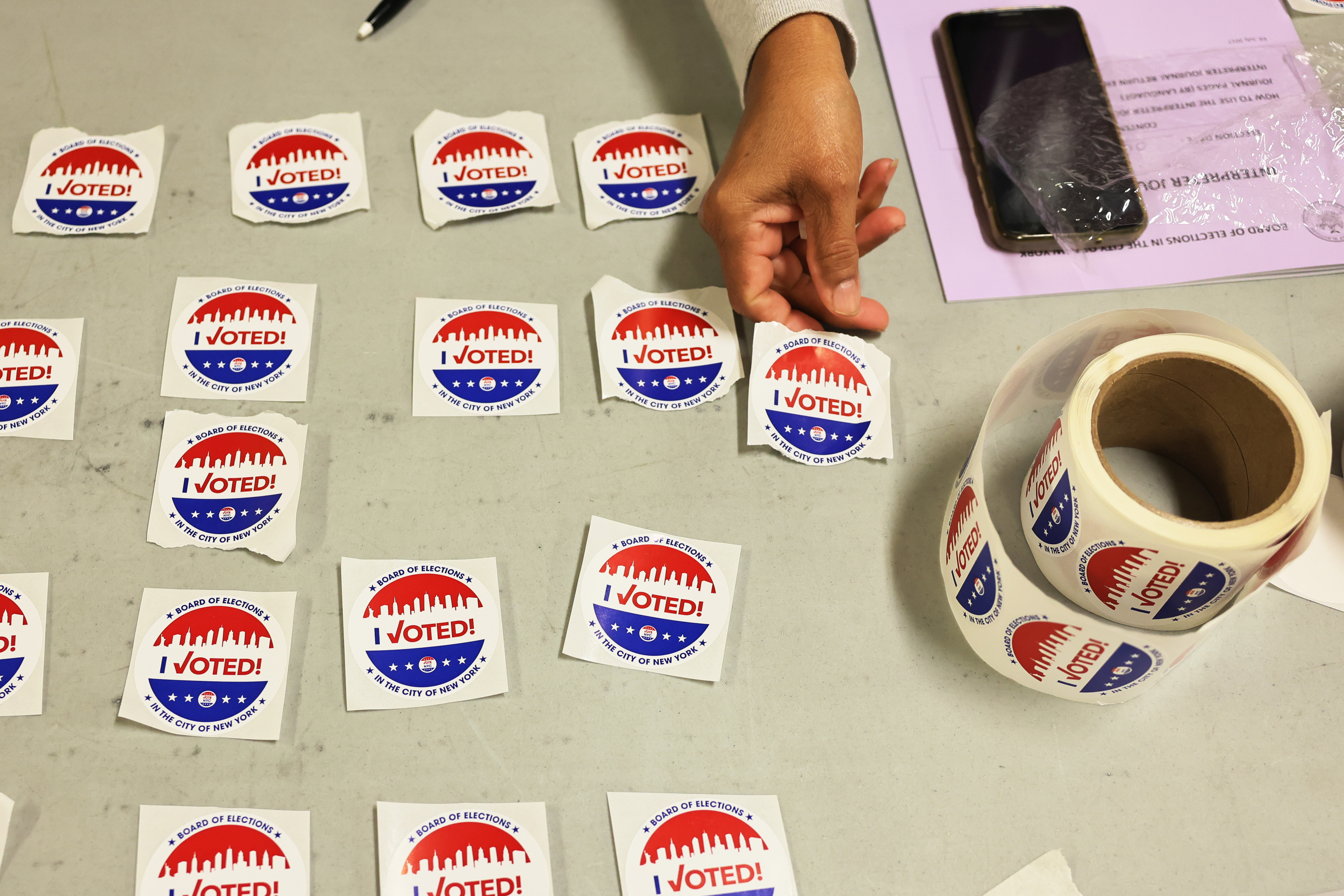 A poll worker hands out I voted stickers at a New York polling site