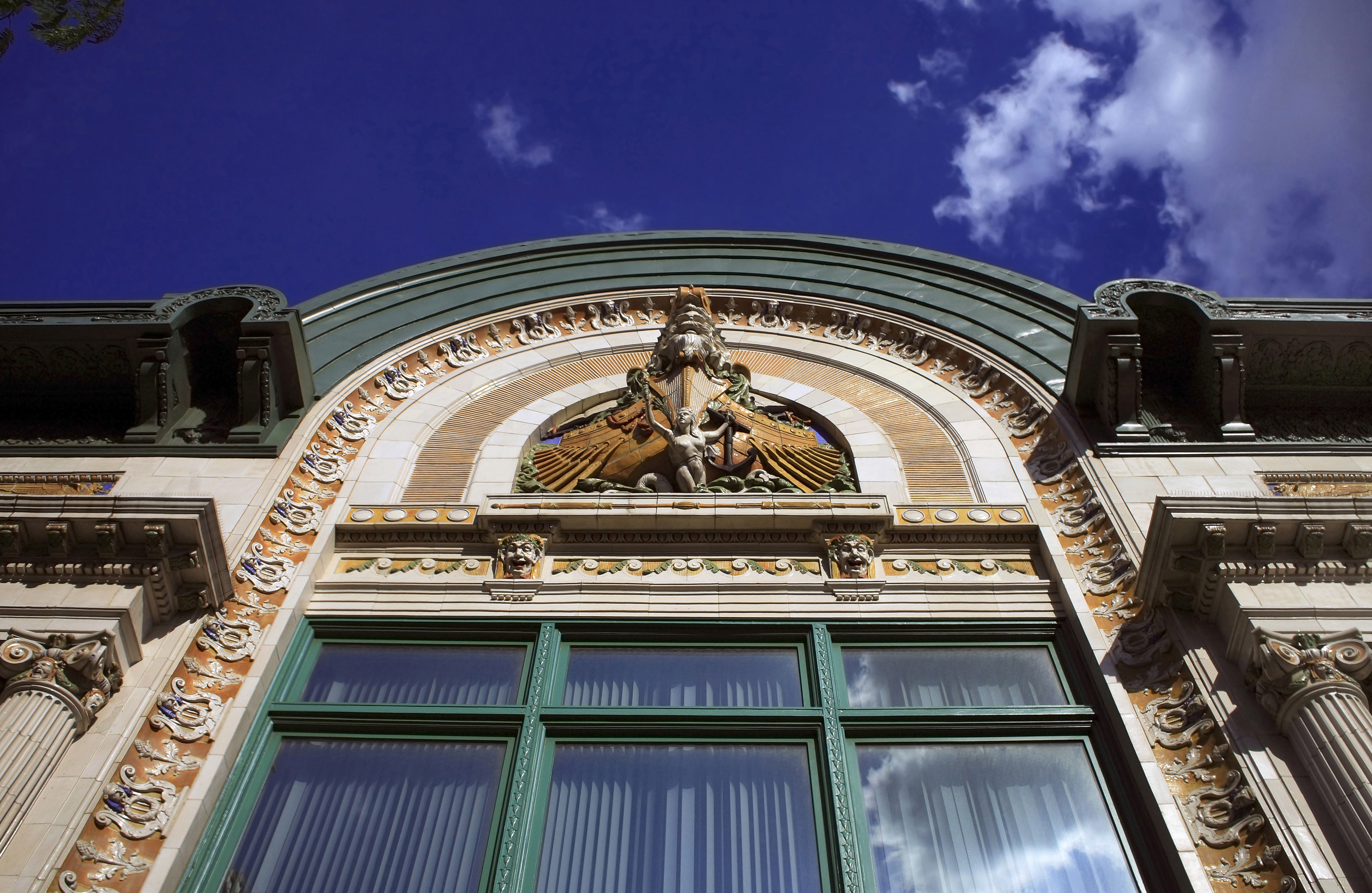 The exterior showing the facade of the Audubon Ballroom, an ornate beige building with gold and turquoise details.