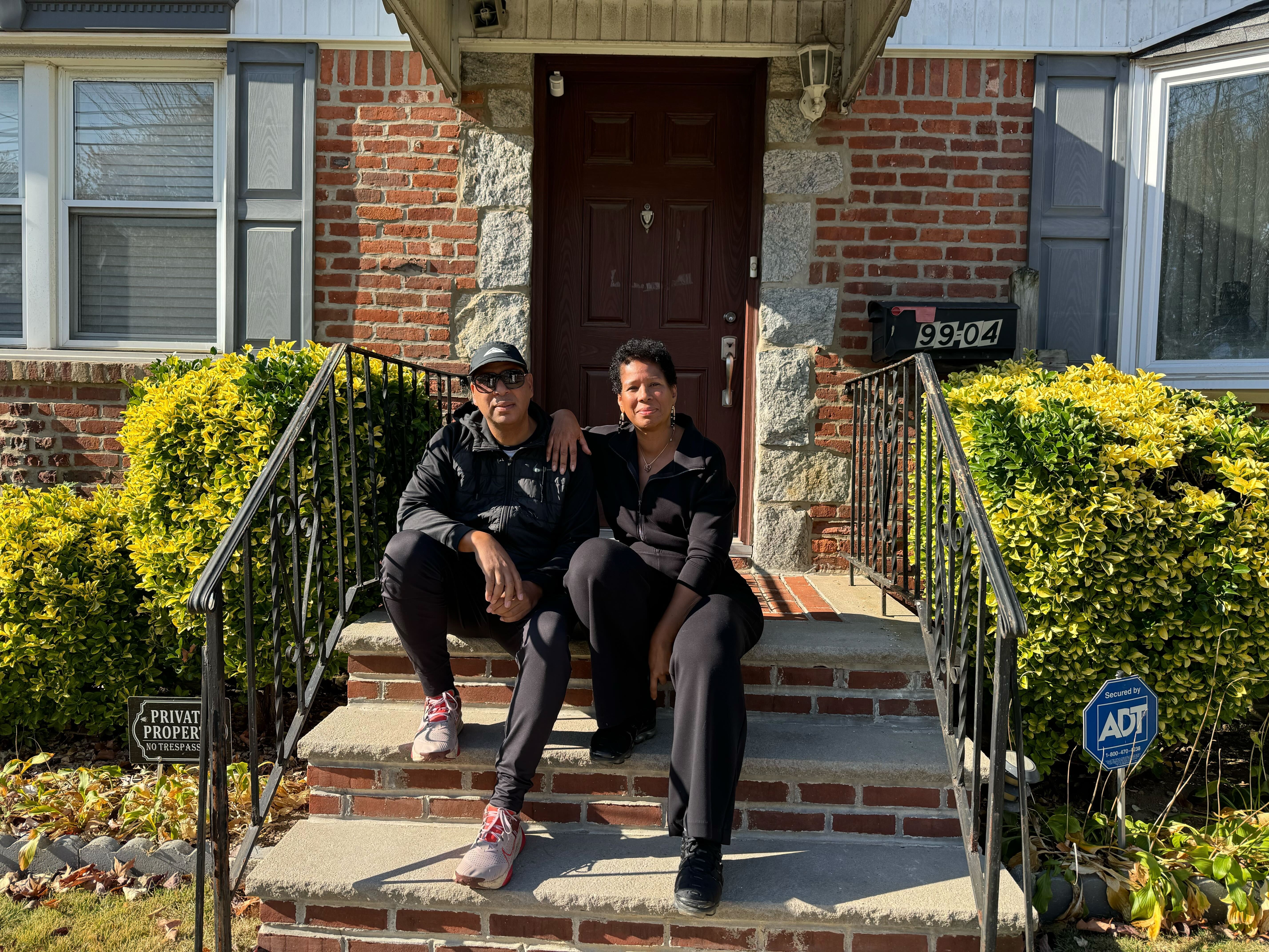 A photo of David Robinson and Teresa Kamara on the stoop of the home where they grew up — 99-04 202nd Street in Hollis, Queens.