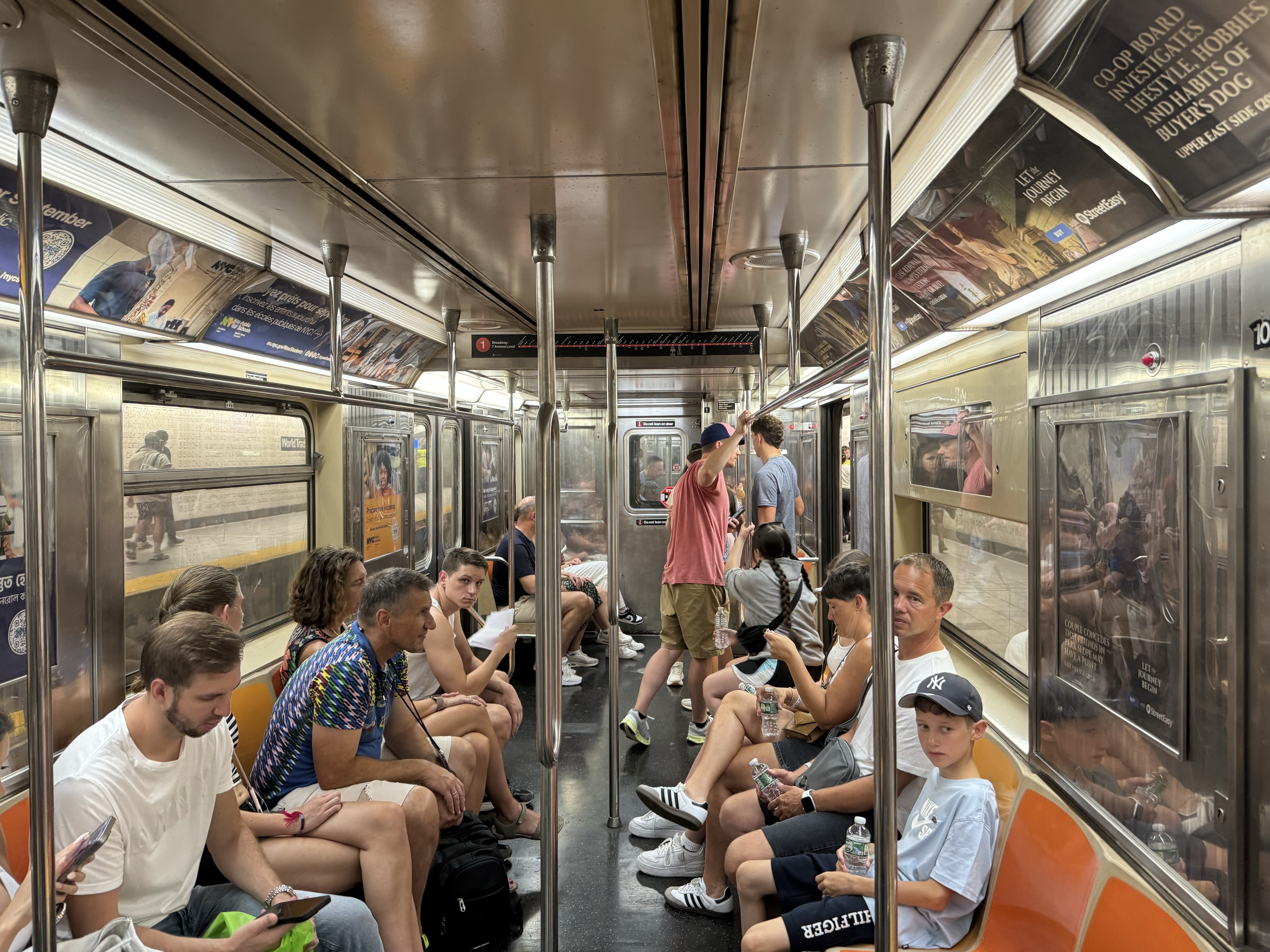 A train car on the subway's 1 line full of riders.
