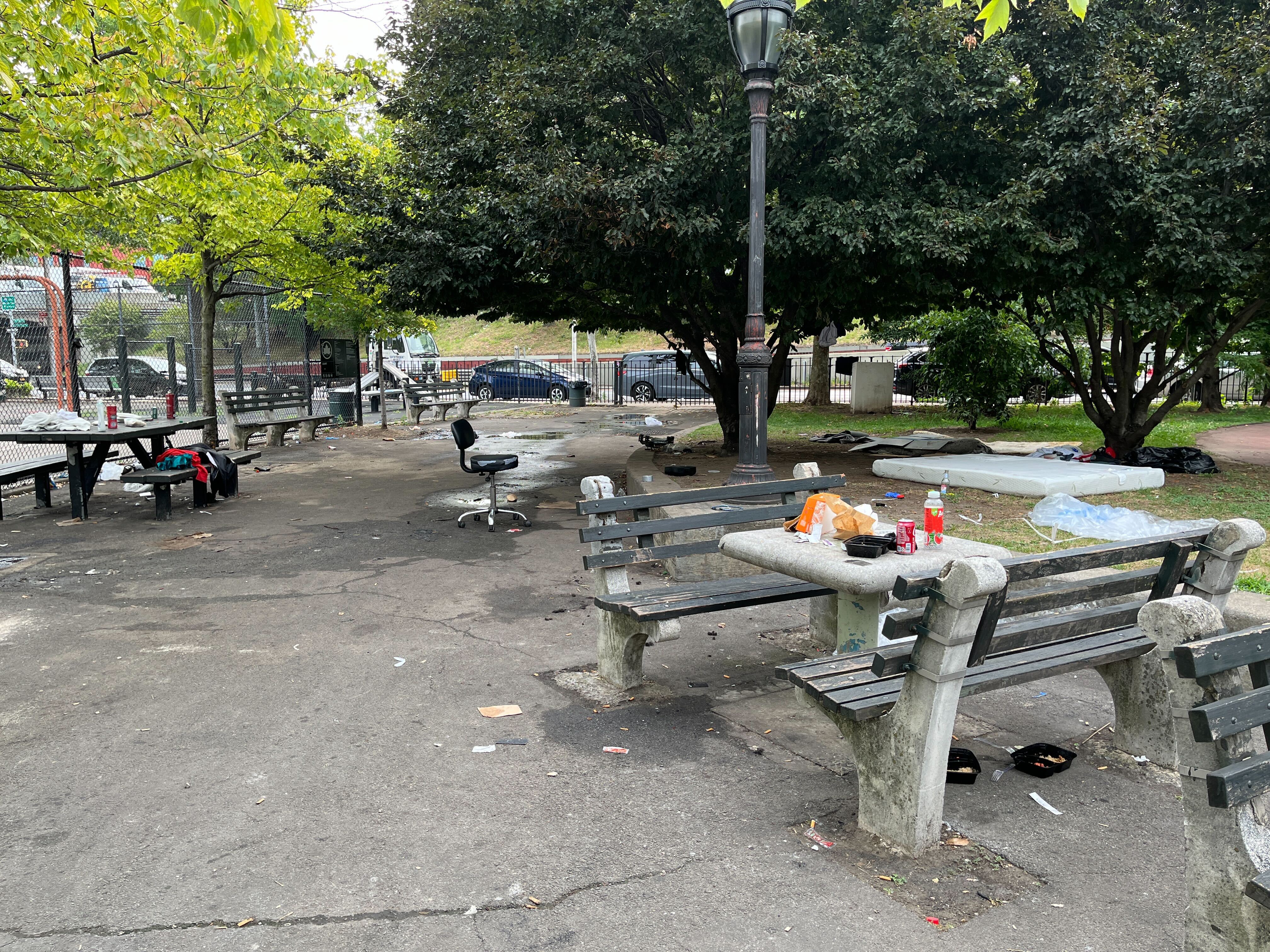 Park benches covered with food and clothing