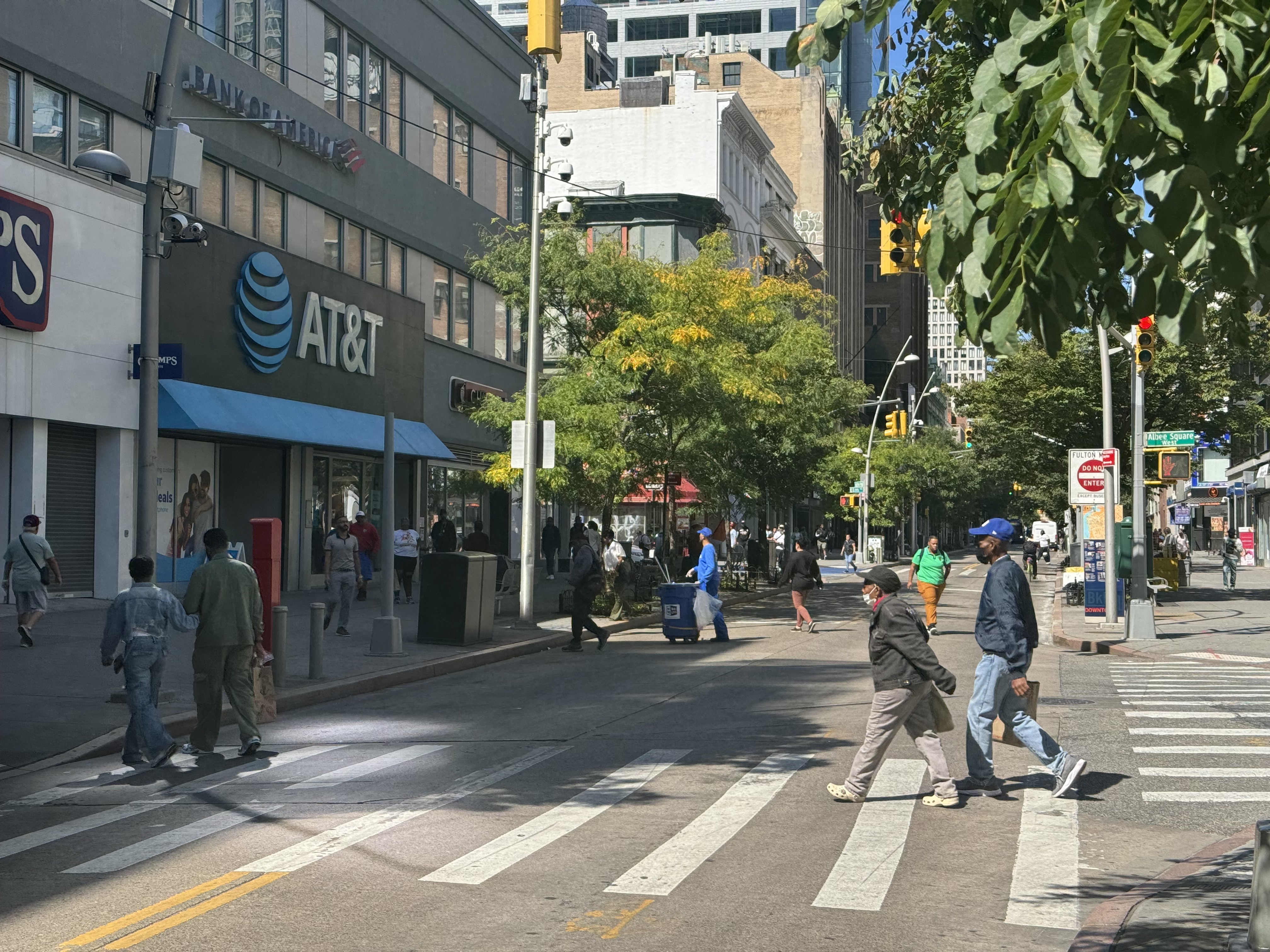 Two people crossing the street in downtown Brooklyn.