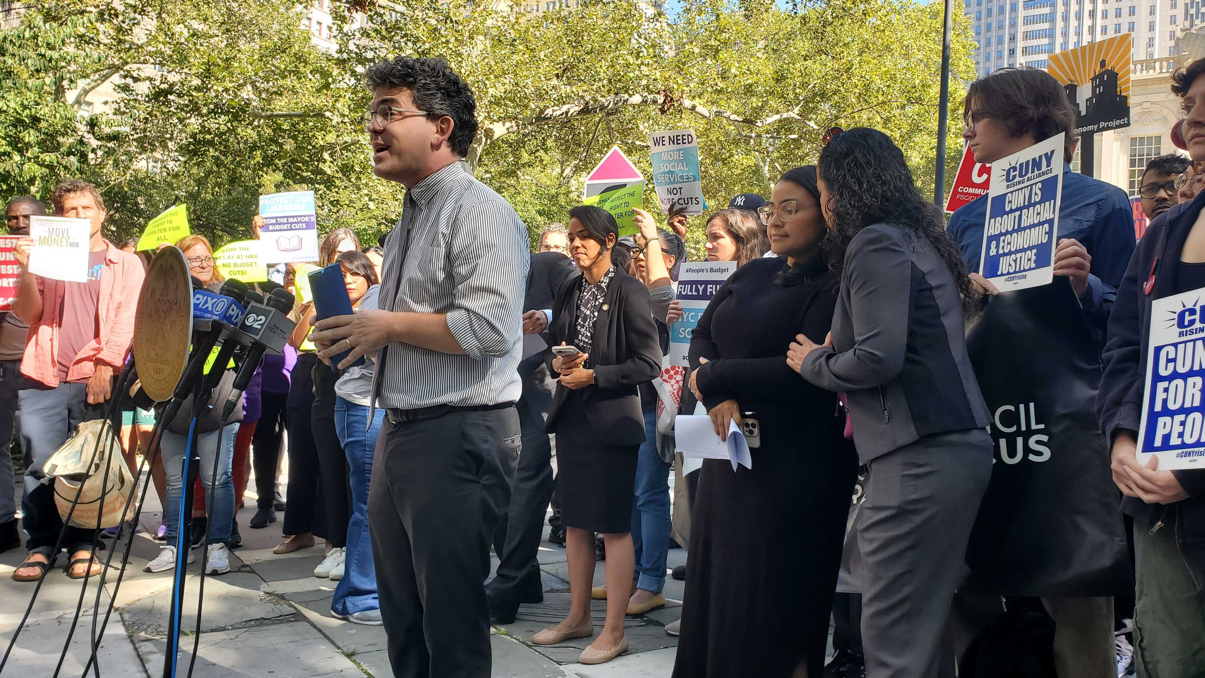 A photo of Councilmember Lincoln Restler protesting budget cuts.