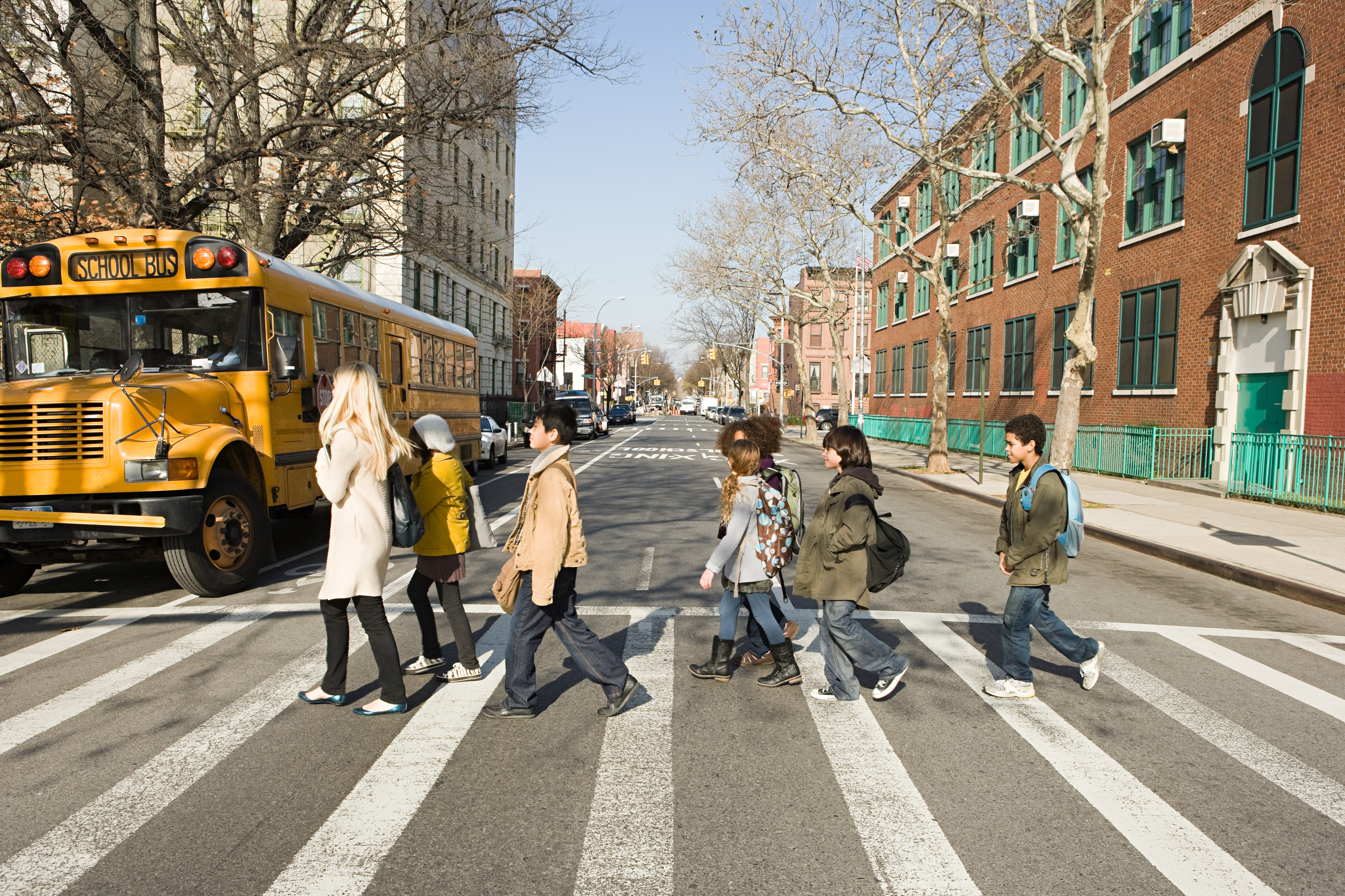 A stock image of a teacher walking with students.