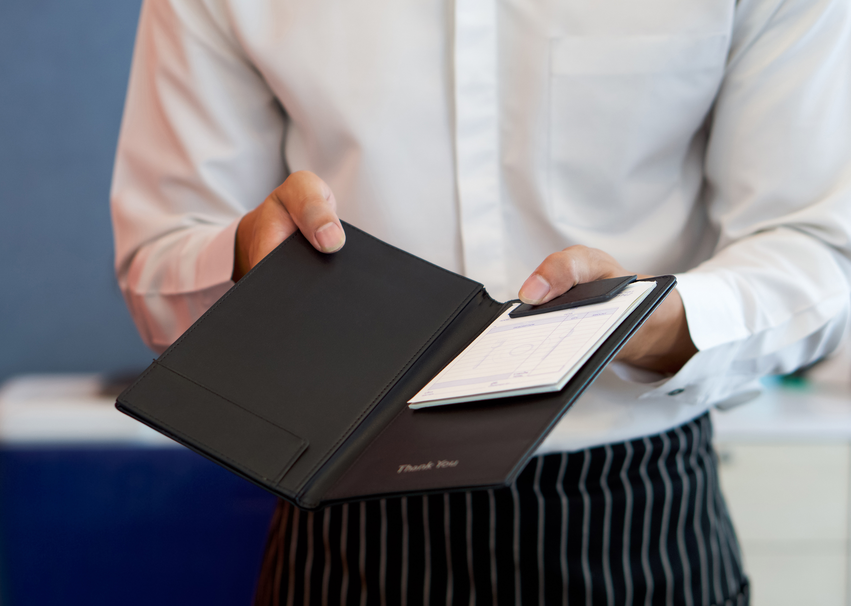 a waiter handing someone the bill