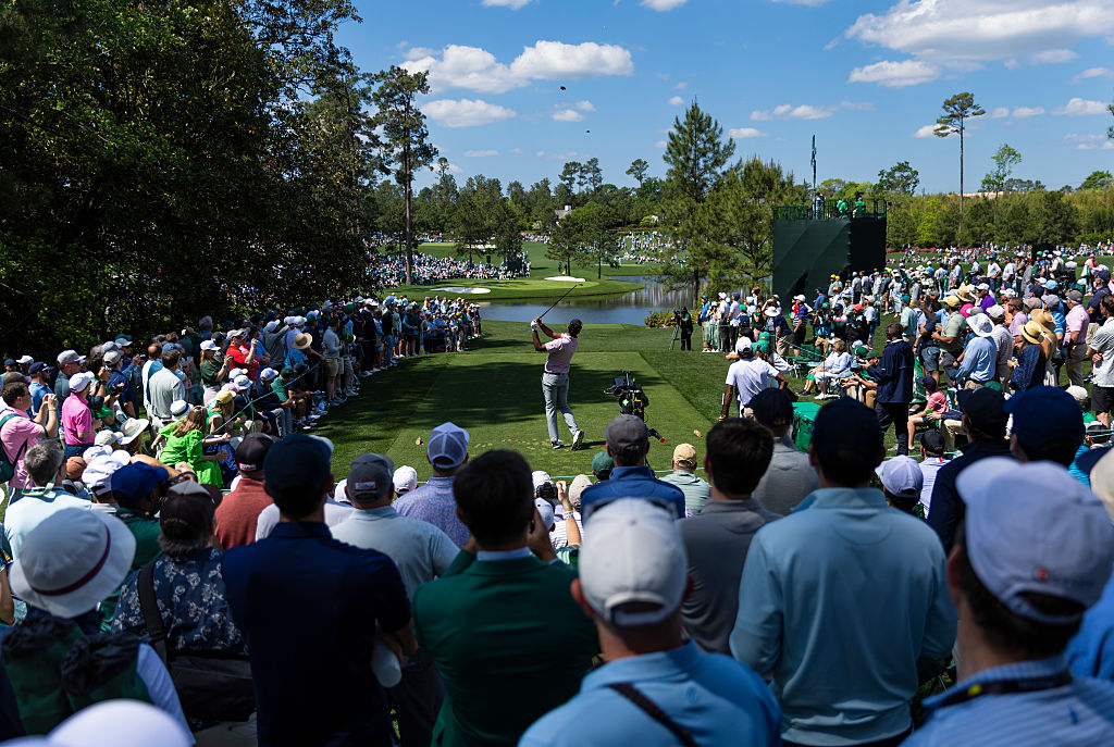 guys watching a golfer hit at the Masters