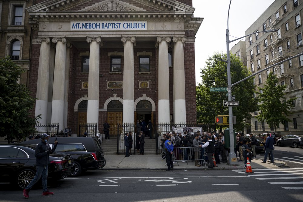 A crowd gathered behind police barricades outside a church.