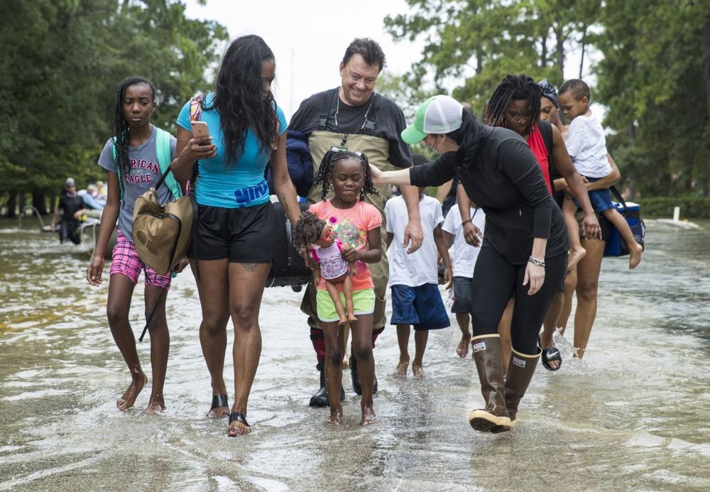The Walker and Brown families walk out of the water at Memorial Drive and North Eldridge Parkway in the Energy Corridor of west Houston, Texas where residents rescued from their flooded homes and apartments due to high water coming from the Addicks Reservoir after Hurricane Harvey<br>(Getty Images)
