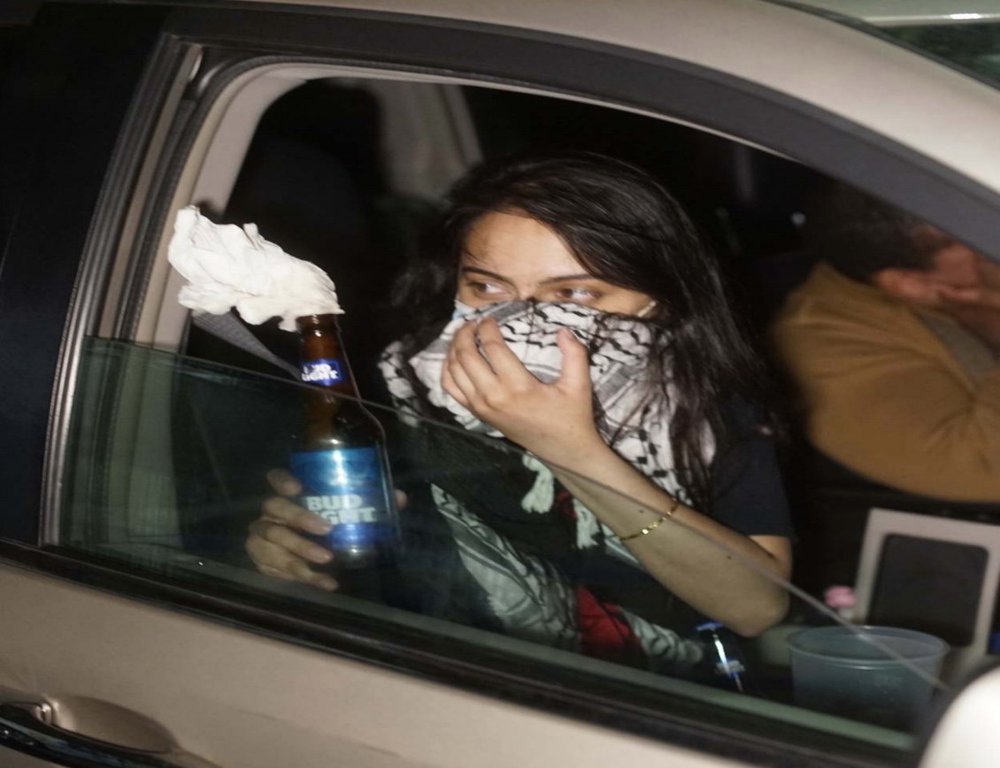 A photo allegedly shows Urooj Rahman holding a Molotov cocktail in the front seat of a car.