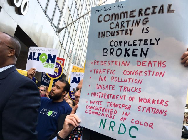 Protesters at a rally last year urging the city to revoke Sanitation Salvage's license. Their license was later suspended, and eventually the company surrendered it.