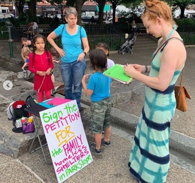 A Park Slope resident signs a petition supporting the opening of new homeless shelters in the neighborhood.