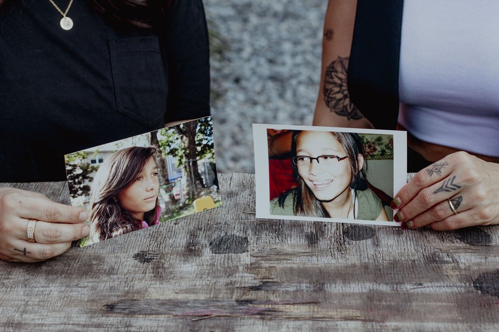 Closeup photo of two hands holding photos of Genesis Reynoso