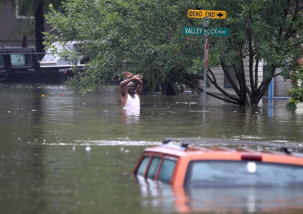 0b2c5d3d7gettyimages-840330608-jpg.jpeg A man waves down a rescue crew as he tries to leave the area after it was inundated with flooding from Hurricane Harvey on August 28, 2017 in Houston, Texas<br>