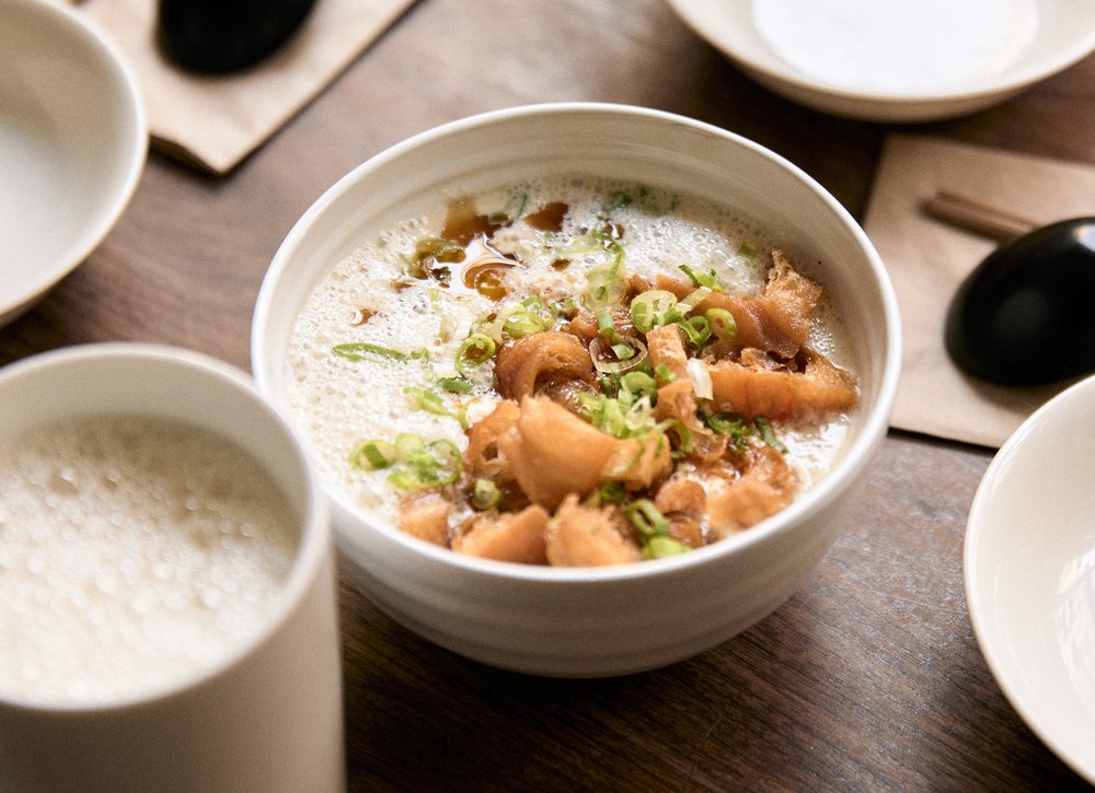 A breakfast dish made with soy milk and served with crumbled bread on top.