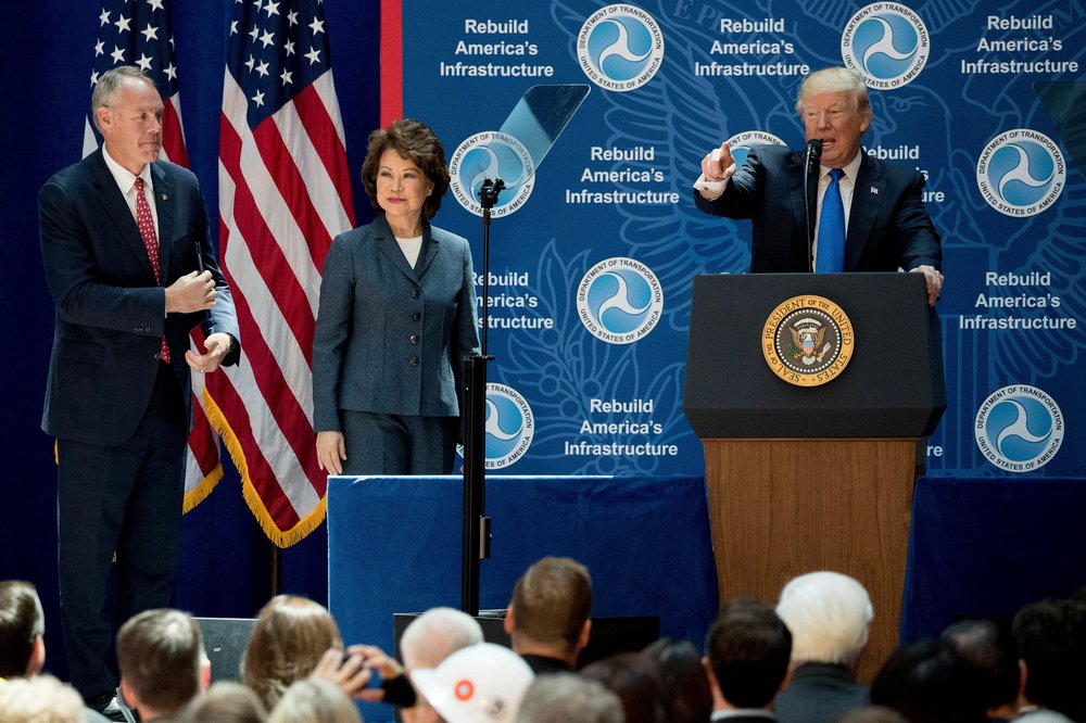Donald Trump, accompanied with Transportation Secretary Elaine Chao, center, and Interior Secretary Ryan Zinke, left, speaks about infrastructure at the Department of Transportation, in Washington in 2017.