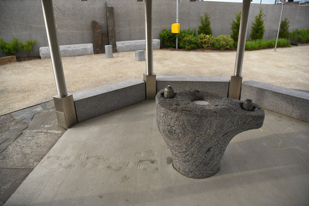 12_Kensinger_Newtown_Creek_Nature_Walk_DSC_2173.jpg Inside the shelter is a water fountain carved out of a 3.5 billion-year-old chunk of Morton Gneiss, one of the Earth’s oldest rocks. The footprints are an homage to the moon landing and early indigenous residents of the creek. May 7th, 2021