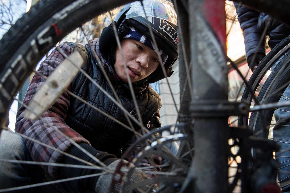 14fd8e0db2018-01-13_heinsebikedigital-4-jpg.jpeg Zhu Xian, 31, fixes a broken wheel in between deliveries from a restaurant on 14th Street.<br/>