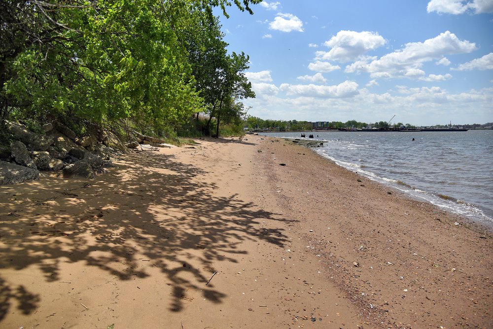 A wide, sandy beach stretches along the site’s Arthur Kill waterfront, at the foot of a 15-foot-high cliff of concrete rubble. The Arthur Kill is a 10-mile-long tidal strait, and its Staten Island shoreline is accessible in just a handful of locations.