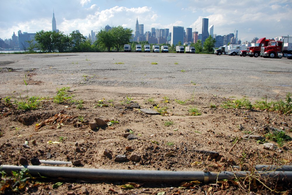 The fenced off waterfront at the northern end of Greenpoint, photographed in 2013. Much of the shoreline here was used for truck parking lots and construction equipment storage yards.