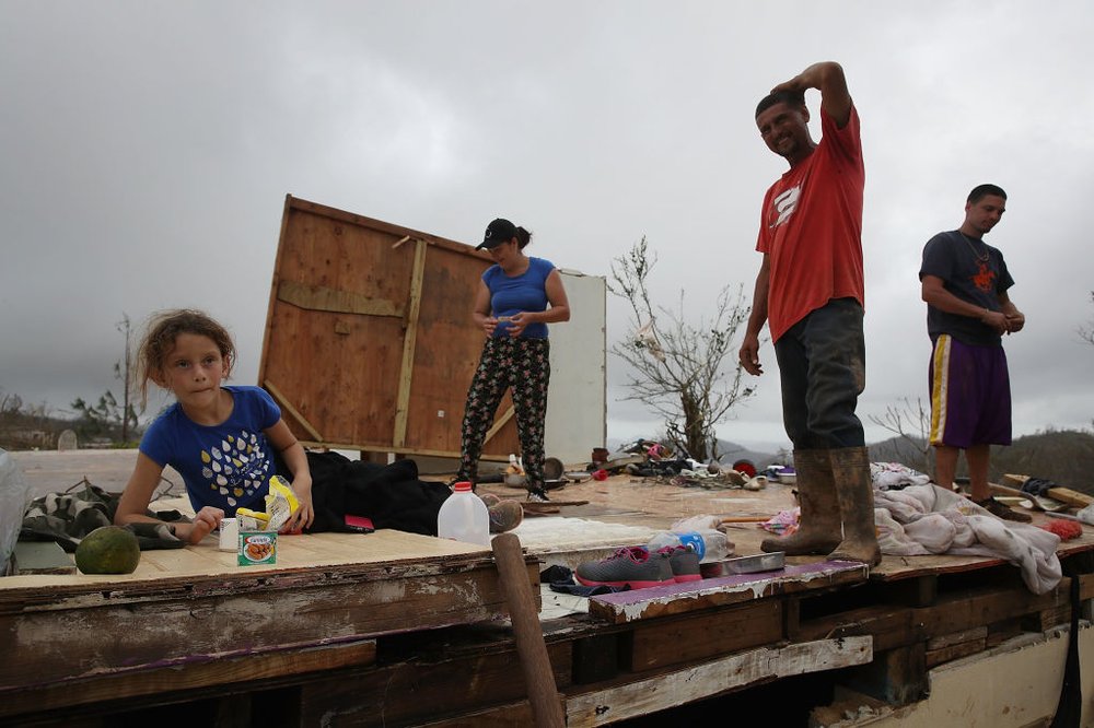1c5cc9570gettyimages-853255766-jpg.jpeg Karlian Mercado, 7, Carmen Maldonado, Carlos Flores and Jose Flores (L-R) stand on what remains of their home after it was blown away by Hurricane Maria as it passed through the area on September 24, 2017 in Hayales de Coamo, Puerto Rico. (Photo by Joe Raedle/Getty Images)