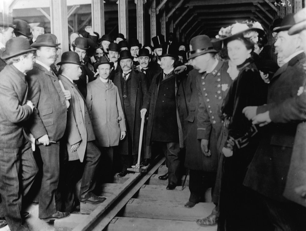 1d3783ea8gettyimages-2507307-jpg.jpeg Mayor Seth Low holds a mallet, surrounded by a crowd of police, officials, and citizens at a dedication ceremony for a New York City subway station, probably the City Hall station, New York City, circa 1903. (Getty)<br/>
