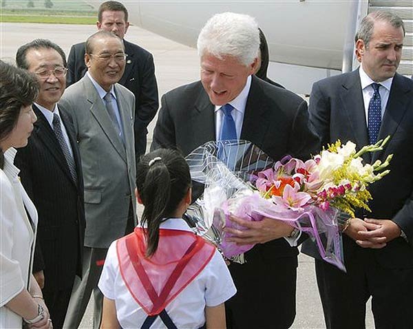 2009_08_nkbc02.jpg Former president Bill Clinton receiving a bouquet of flowers upon his arrival at an airport in Pyongyang