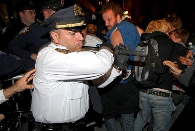 2011_10_ows08.jpg A police officer uses his baton against protestersâand, apparently, media