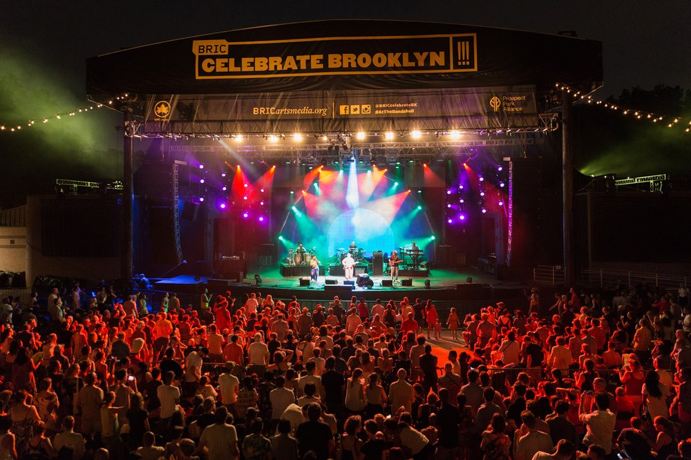 A crowded outdoor concert venue illuminated after dark