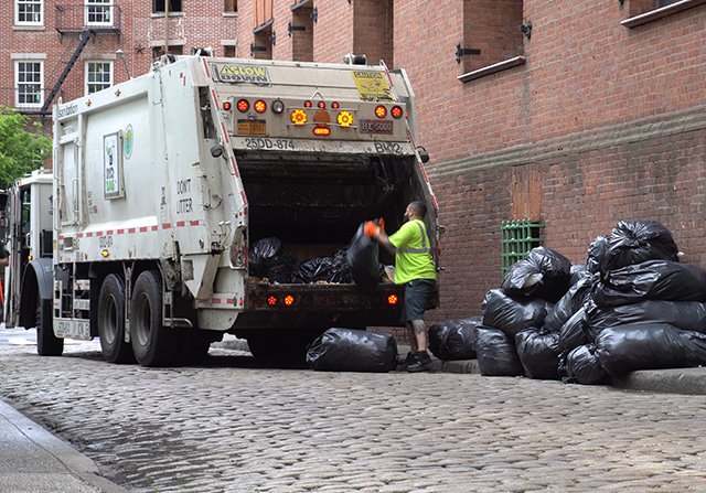 A sanitation worker with truck