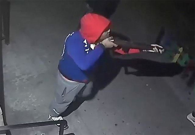 Image of the suspect holding a long firearm