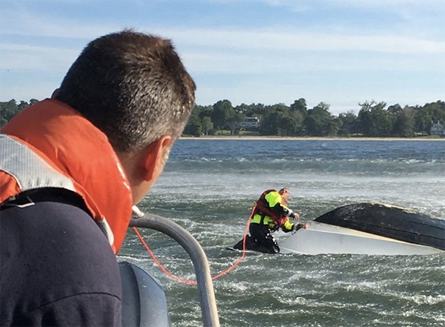 Firefighters responding to the overturned boat