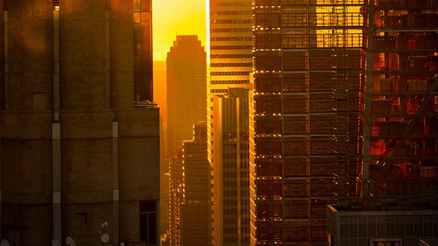 The sun shines through Manhattan buildings