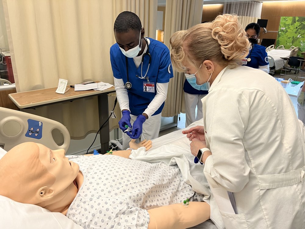 Clinical instructor Karen Colombo offers feedback as nursing student Mouaze Adam practices drawing blood on a dummy at the SUNY Downstate College of Nursing. “There's no better time than now to go into nursing, mainly because we are fighting for better conditions,” Adam said.