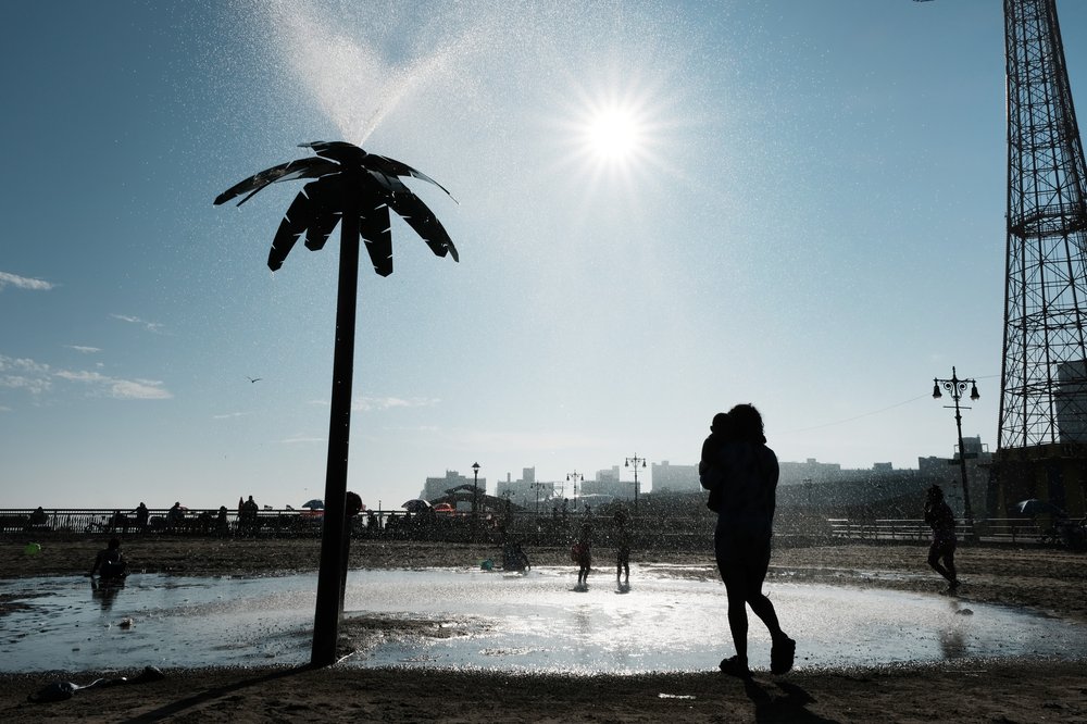 People cool off under a fountain in Coney Island on a hot afternoon on July 6, 2023.