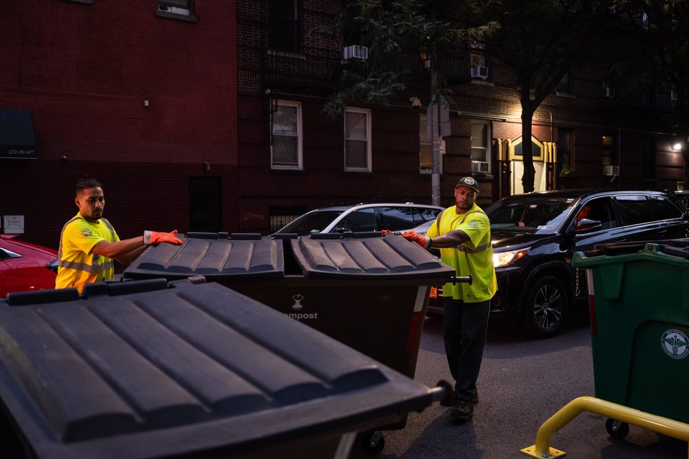 DSNY workers return the trash and compost bins to their stations after about 10 minutes spent emptying them, Aug. 16, 2023.