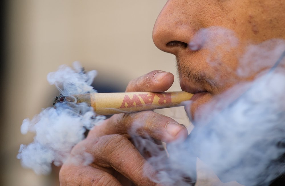 A person smokes marijuana during the annual NYC Cannabis Parade & Rally in support of the legalization of marijuana for recreational and medical use on May 1, 2021 in New York City