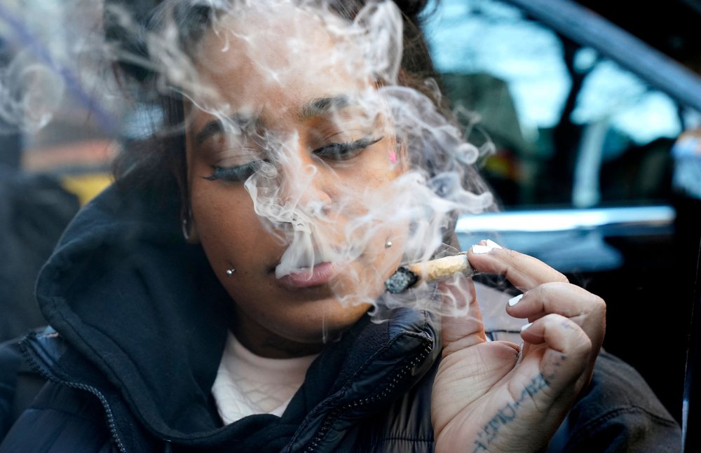 A customer smokes marijuana during the grand opening of Smacked dispensary in Greenwich Village, Jan. 24, 2023.