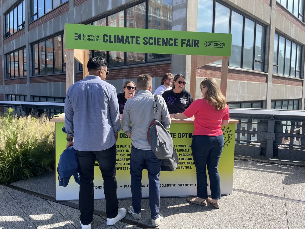 Climate science fair attendees stop at one of the information booths for a map of exhibits and swag.