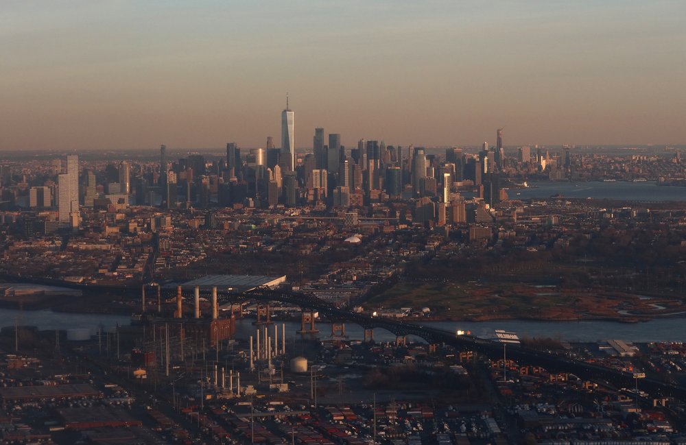 Kearny, New Jersey (foreground) and Jersey City sit across from lower Manhattan’s skyline and One World Trade Center as the sun sets on Jan. 4, 2022 in this aerial photo taken from Newark. A recent federal analysis identified a waste site in Kearny that could be threatened by sea level rise and climate change.