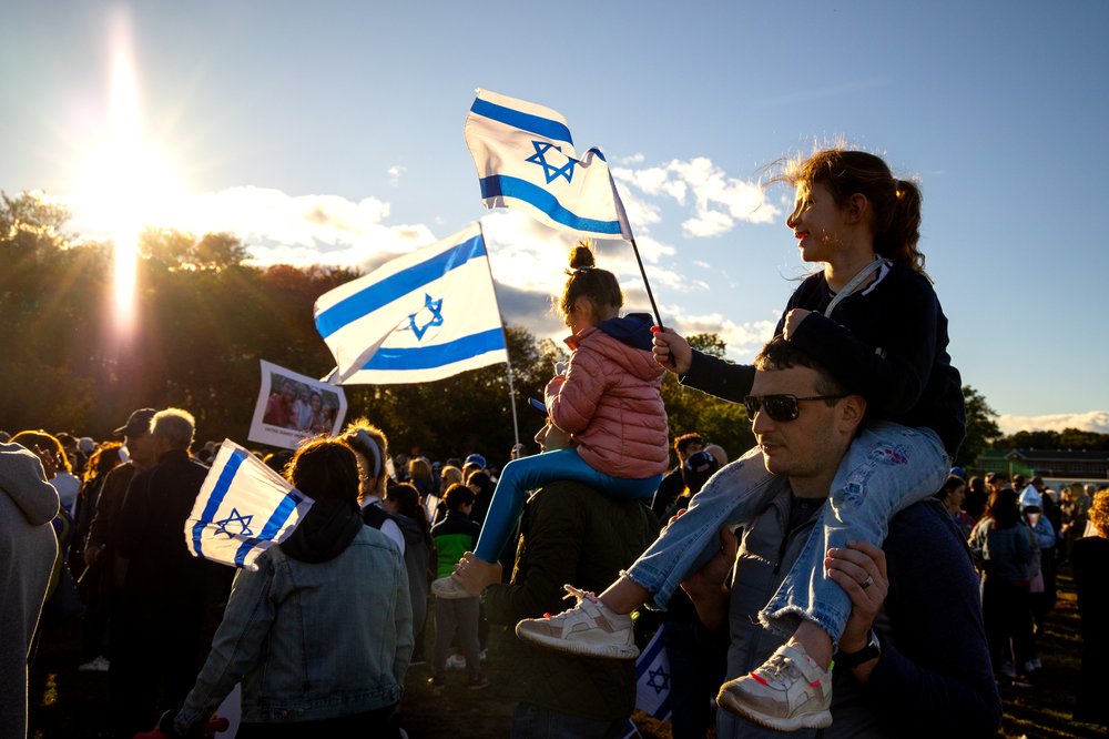 Marchers waving Israeli flags, some joined by their children