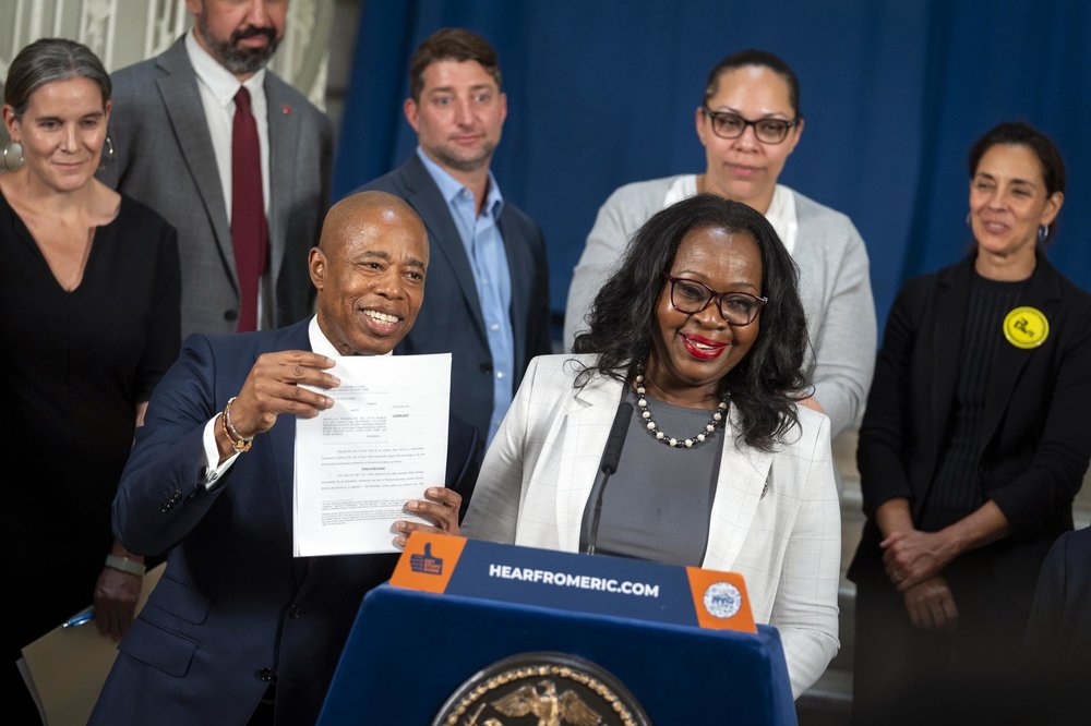 Mayor Eric Adams and New York City Corporation Counsel Sylvia O. Hinds-Radix stand at podium in City Hall to announce that the City of New York is filing a federal lawsuit against four major distributors of flavored disposable e-cigarettes, the most popular vaping devices among middle-school children and high school youth. Adams holds up a copy of the lawsuit. Photo taken July 10, 2023.