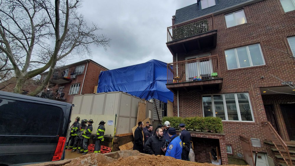 A photo of officials at the site of a fatal building collapse in Borough Park.