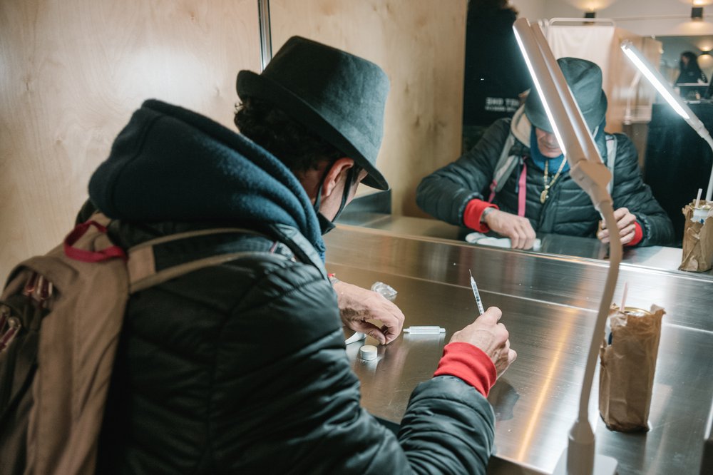 A man prepares to inject drugs at one of the booths in the overdose prevention center in Harlem.