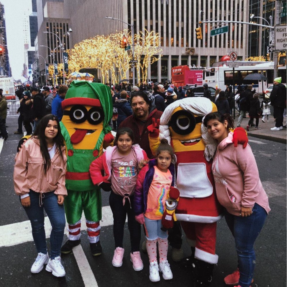 Guillermo Frestan and his family pose with cartoon characters in NYC.