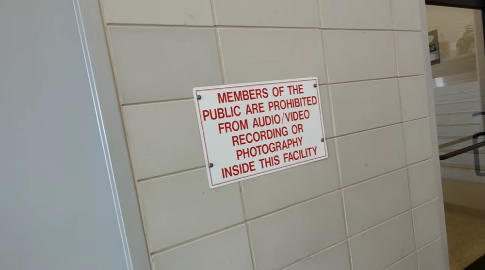 Reyes shows his online viewers a message posted in the NYPD's 121st Precinct on Staten Island that warns people not to record or photograph inside the building.