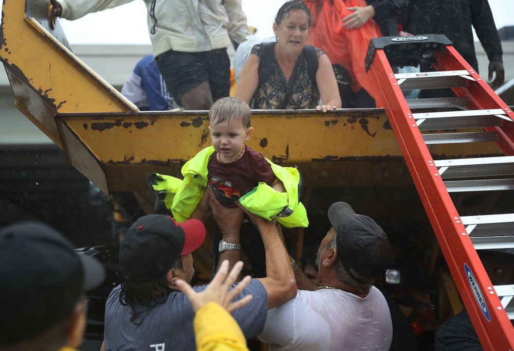 28e656575gettyimages-840331568-jpg.jpeg A child is helped off the back of a rescue truck after his family evacuated their home after it was inundated with flooding from Hurricane Harvey on August 28, 2017 in Houston, Texas<br>